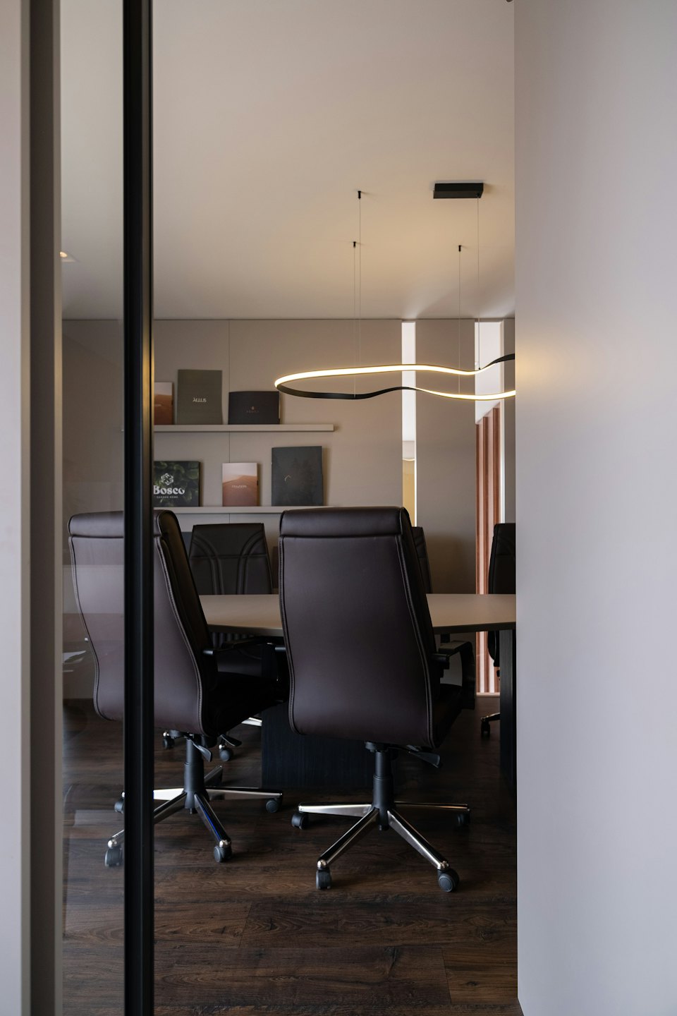 Modern conference room with executive chairs around a large meeting table.